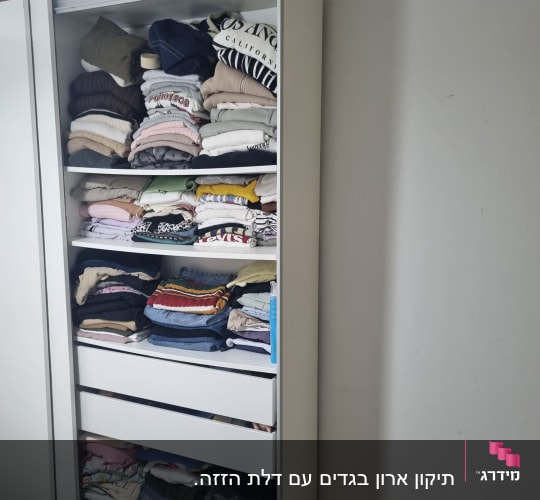 ארון בגדים לבן עם מדפים ומגירות פתוחות